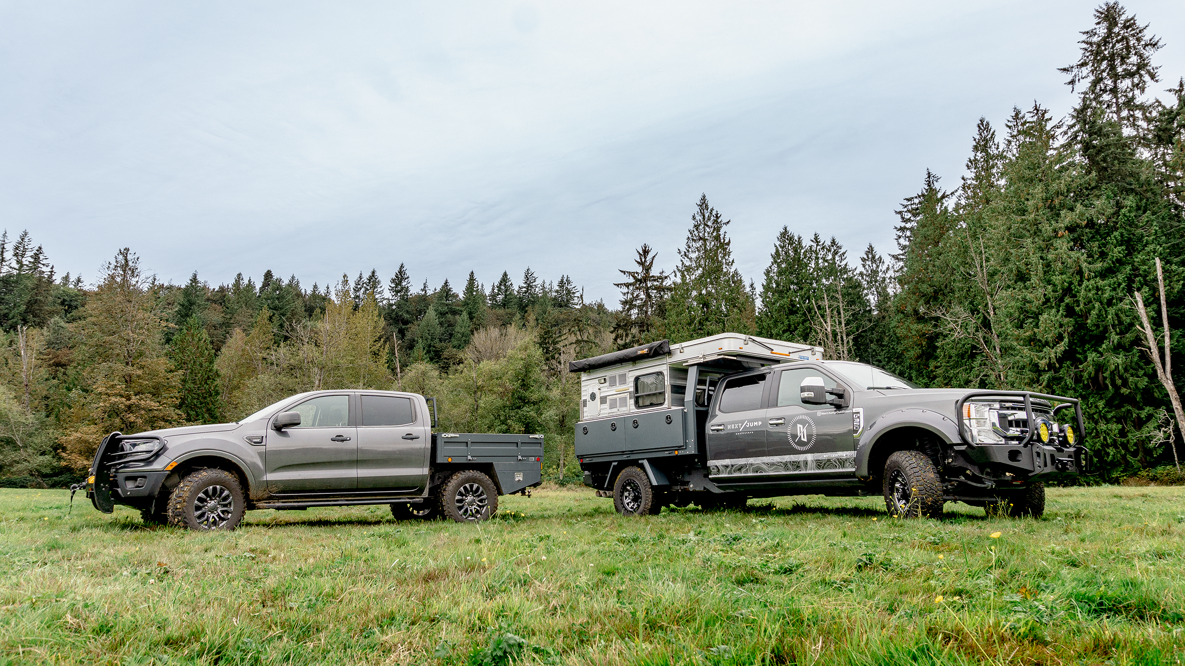 Two ford pickups with next jump flatbed parked in open field on green grass